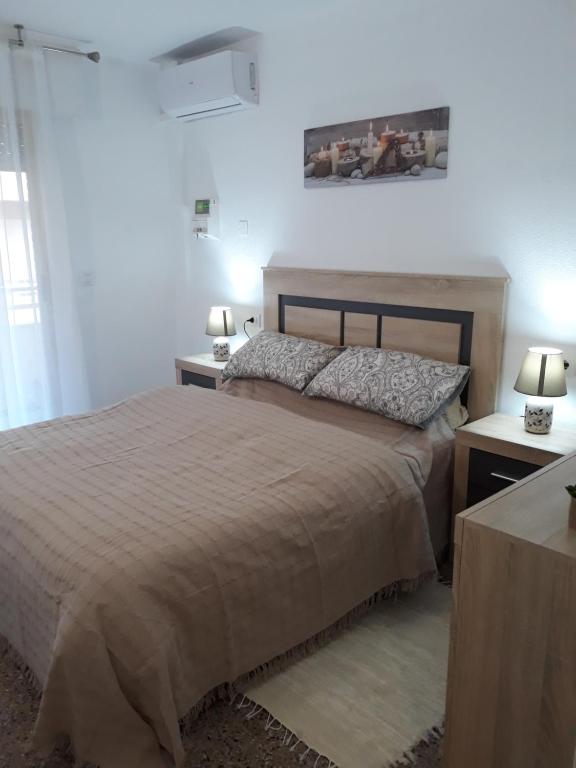 sypialnia z dużym łóżkiem z dwoma stołami i dwoma lampami w obiekcie Apartamento Vacacional w mieście Torrevieja
