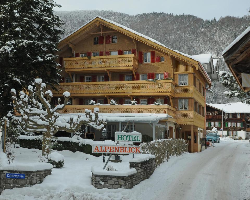un gran edificio de apartamentos de madera en la nieve en Alpenblick Hotel &amp; Restaurant Wilderswil by Interlaken, en Wilderswil