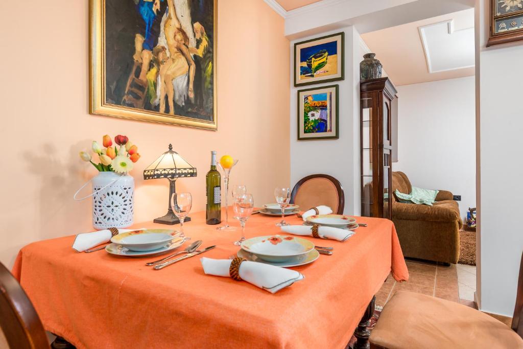 uma sala de jantar com uma mesa com uma toalha de mesa laranja em Apartment Noa Opatija em Opatija