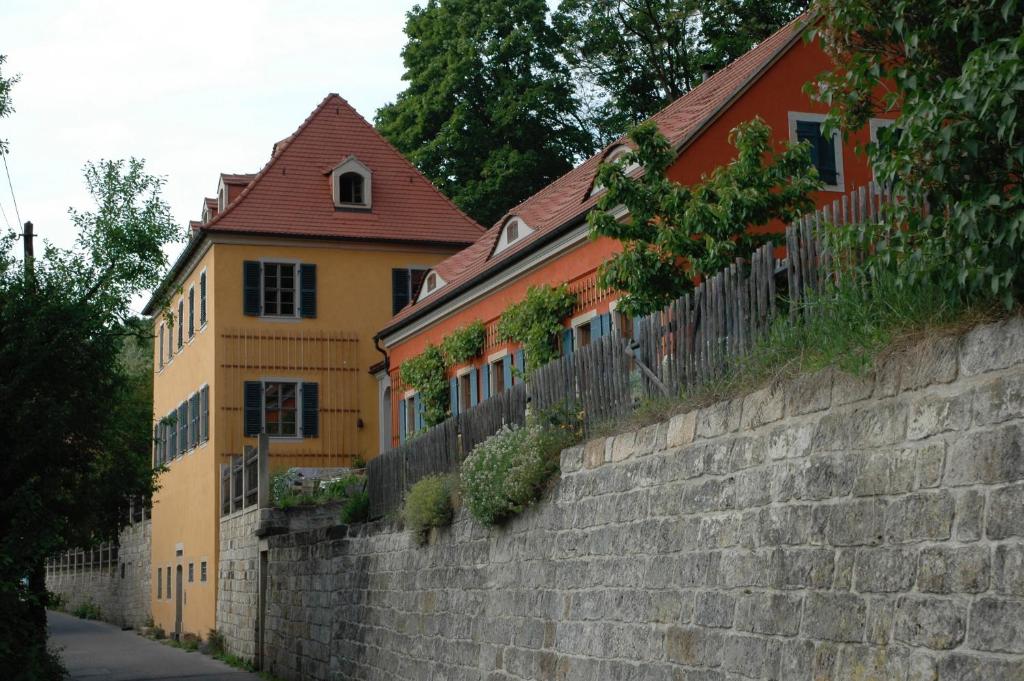 a yellow and orange house behind a stone wall at Dichterhaus Dresden in Dresden