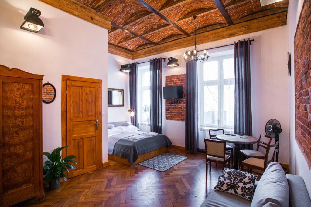 sypialnia z łóżkiem i stołem w pokoju w obiekcie Lovenovsky Apartments w Krakowie