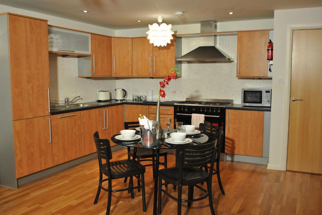 a kitchen with a table and chairs in a room at Dreamhouse Apartments Edinburgh City Centre in Edinburgh