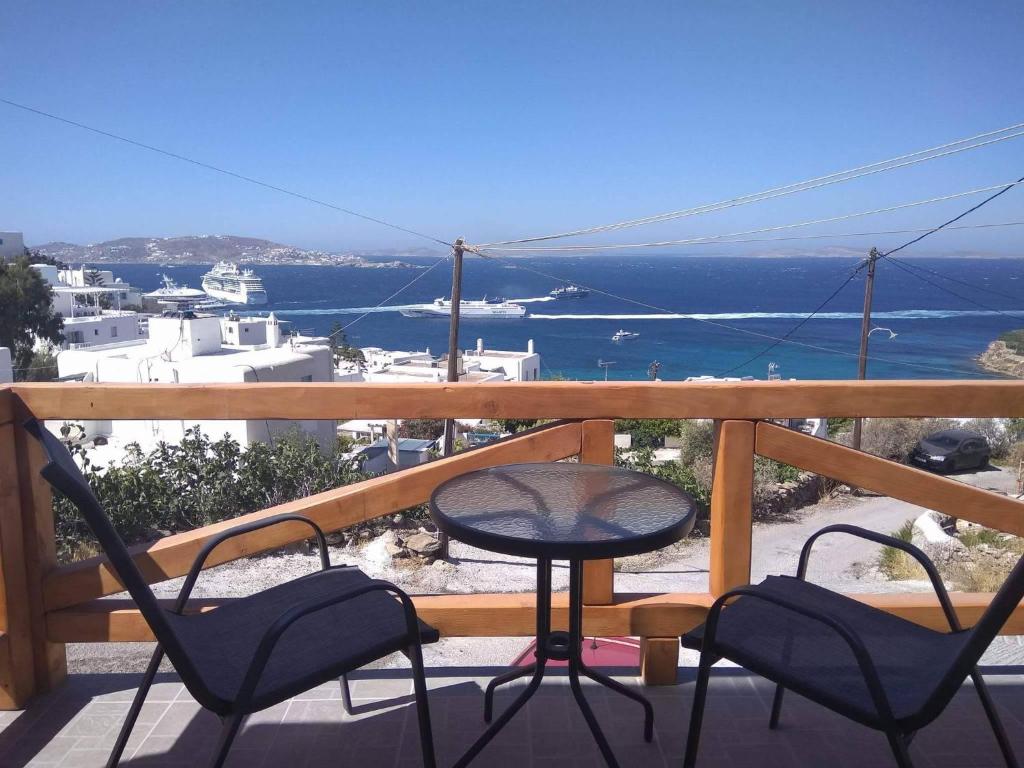 uma varanda com cadeiras e uma mesa e o oceano em Amarain Mykonos em Agios Stefanos