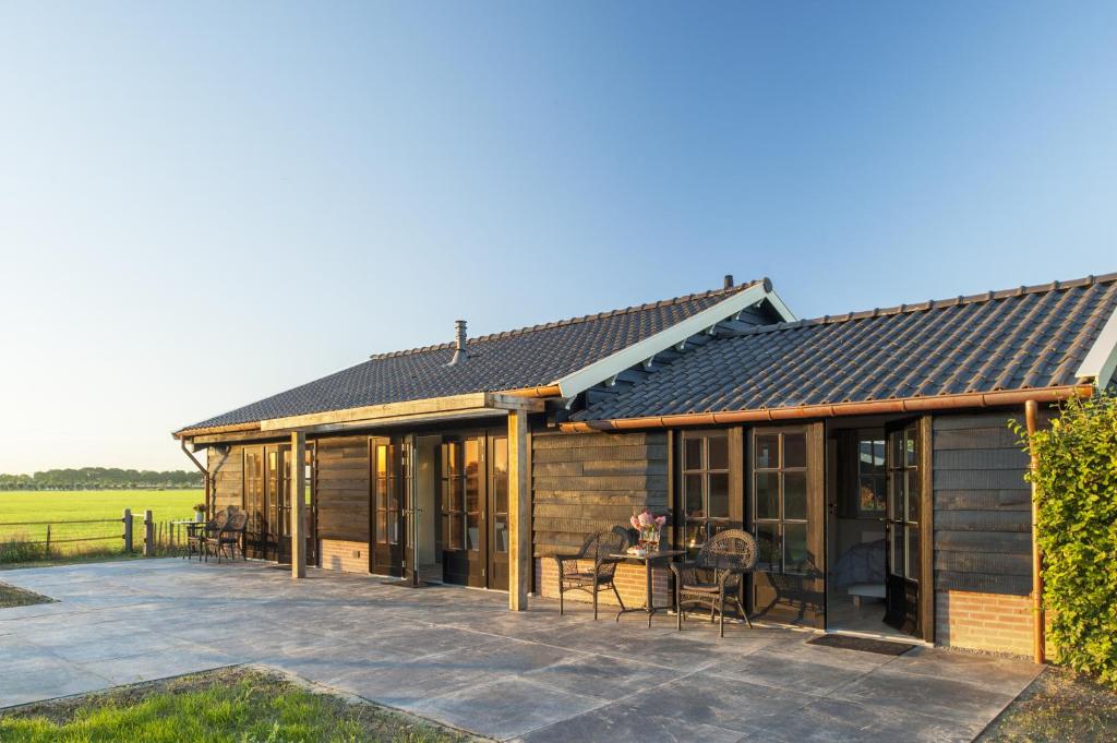 a house with a pitched roof and a patio at Dromen in Drempt in Drempt