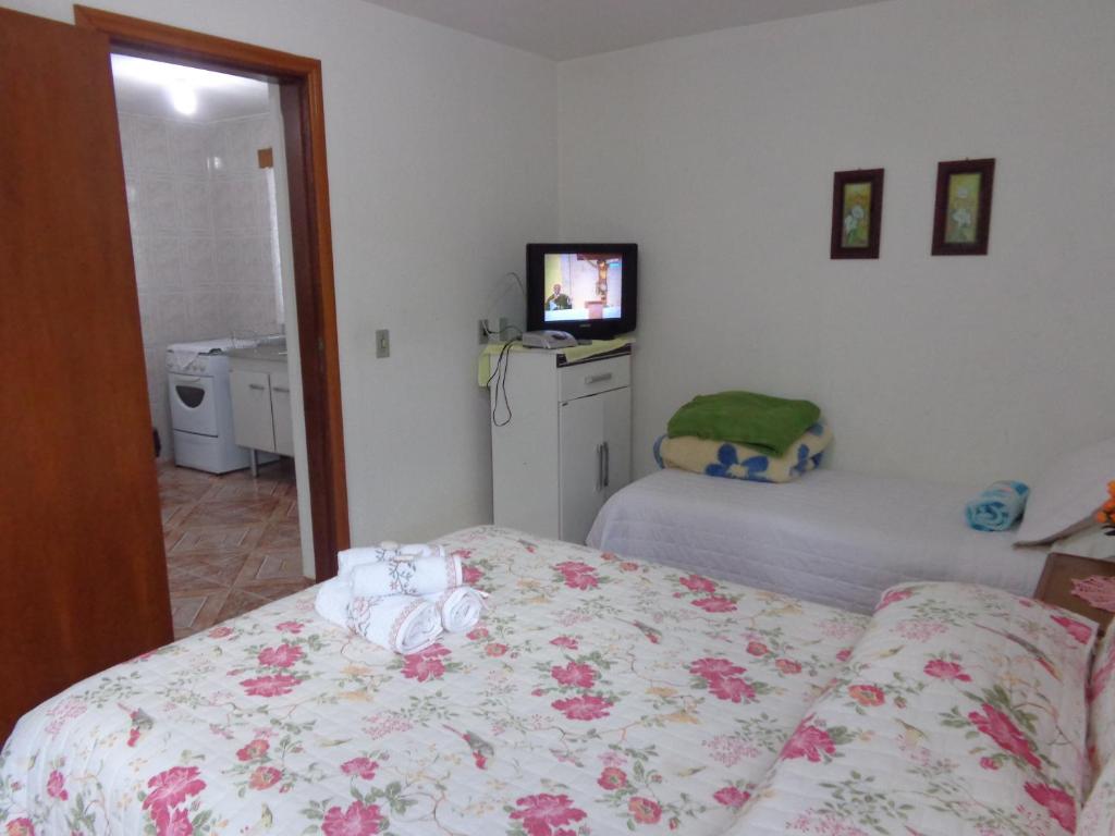 a bedroom with a bed and a television in it at Recanto Monte Verde in Monte Verde