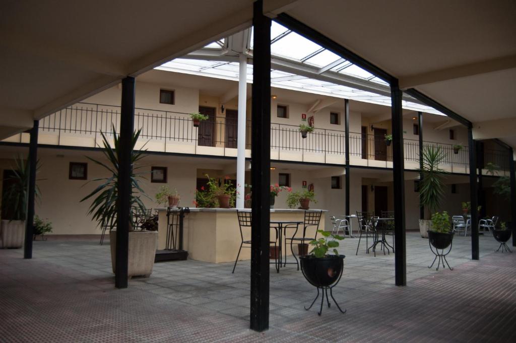 an empty courtyard with tables and chairs in a building at Hotel Urgaín in Oronoz-Mugaire