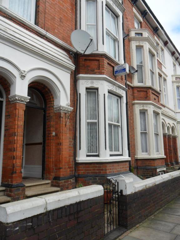 a red brick house with a door and windows at Comfort Guest House in Leicester
