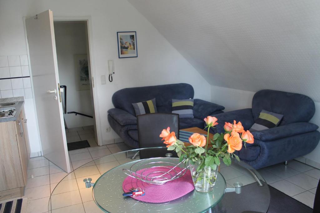 a living room with a glass table with a vase of flowers at Am Ostseestrand in Zingst