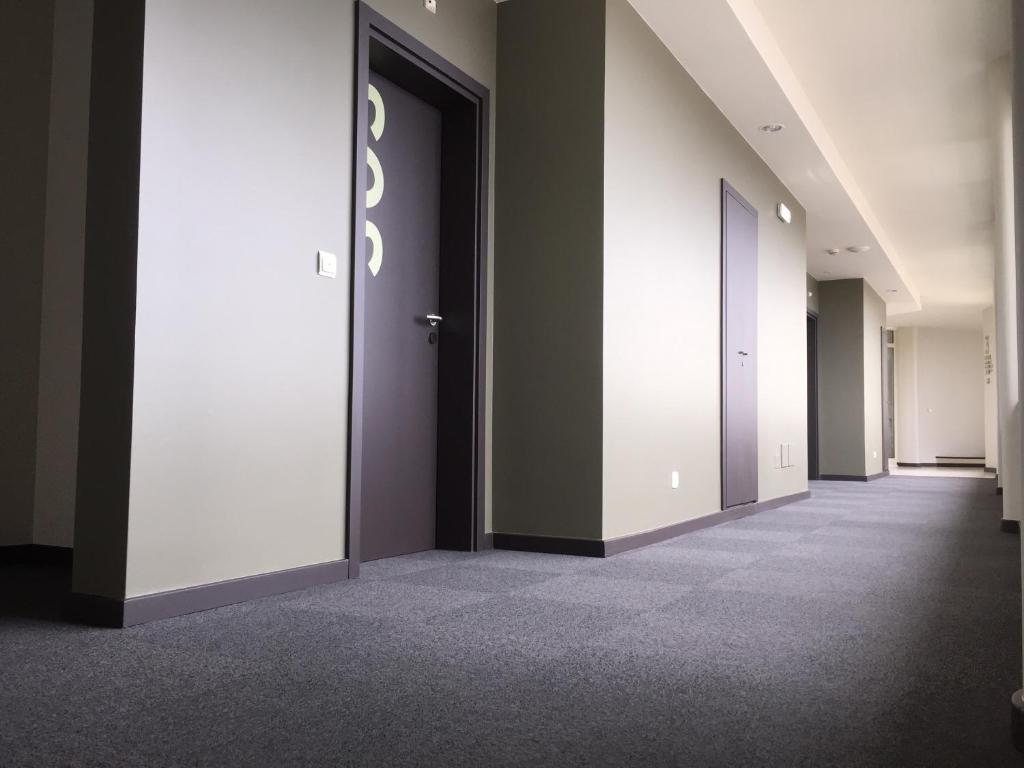 an empty corridor of an office with two doors at Hotel Euro Moniz in Porto Moniz