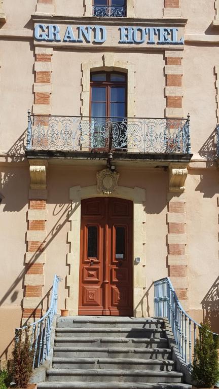 - un bâtiment avec une porte et des escaliers devant dans l'établissement Aulus-les-Bains, à Aulus-les-Bains