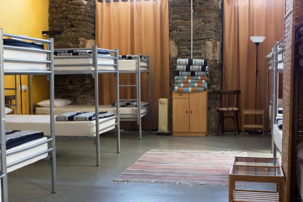 Habitación con varias literas y alfombra. en Albergue San Lázaro, en Sarria