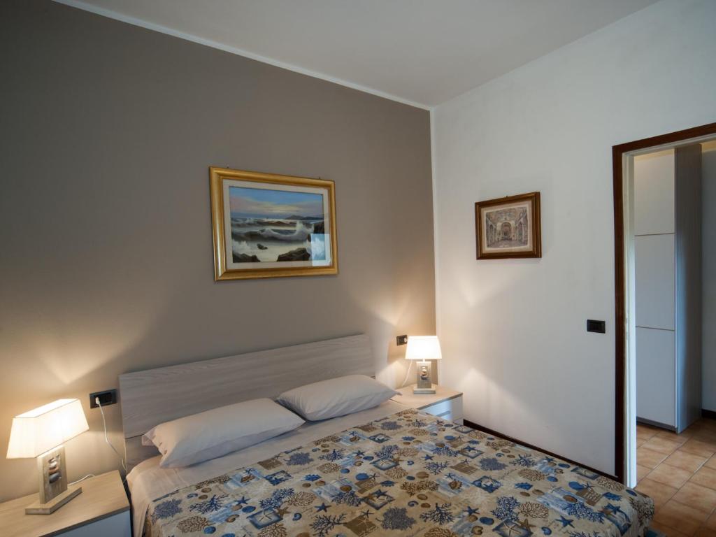 een slaapkamer met een bed, 2 lampen en een spiegel bij Casa vacanze da Carla in Abbadia Lariana