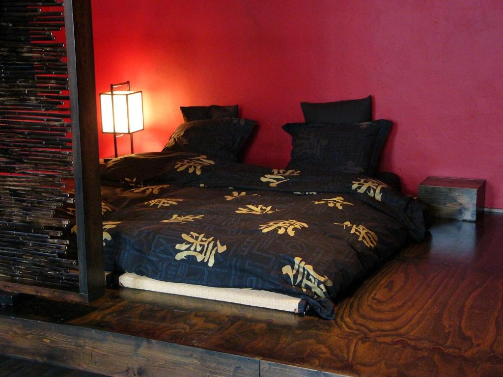 a bed in a bedroom with a red wall at B&B Lady Jane in Bruges