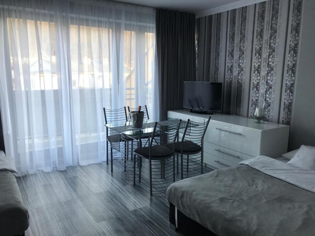 ミエンジズドロイェにあるApartament Villa Mareaのテーブル、椅子、ベッドが備わる客室です。