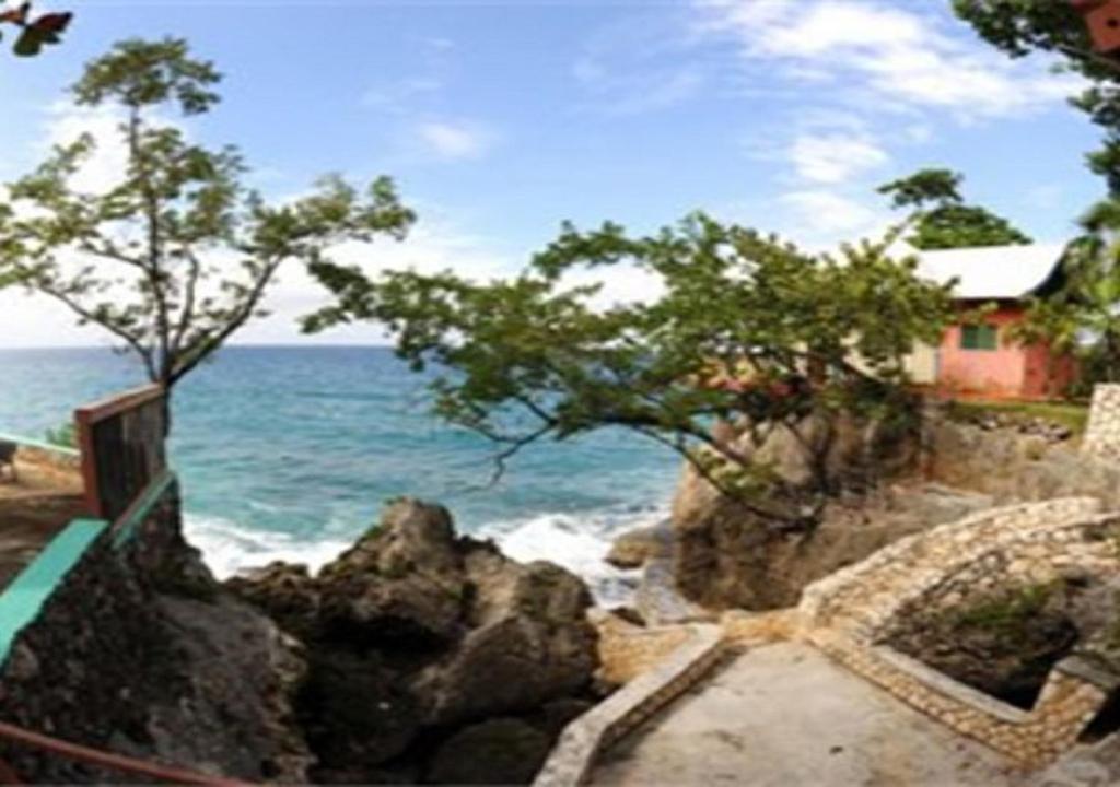 a stairway leading to the ocean with a house at Xtabi Resort in Negril
