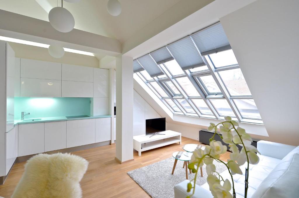 een woonkamer met een witte bank en een dakraam bij Designer Loft 2 in Praag