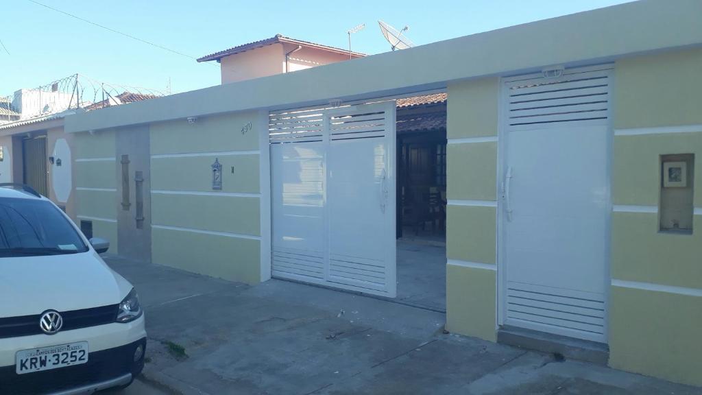 a car parked next to a building with two garage doors at Kitinetes - com WiFi - frigobar - TV- Cozinha completa in Rio das Ostras