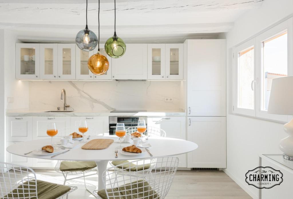 a white kitchen with a white table and chairs at Charming Madrid Plaza in Madrid