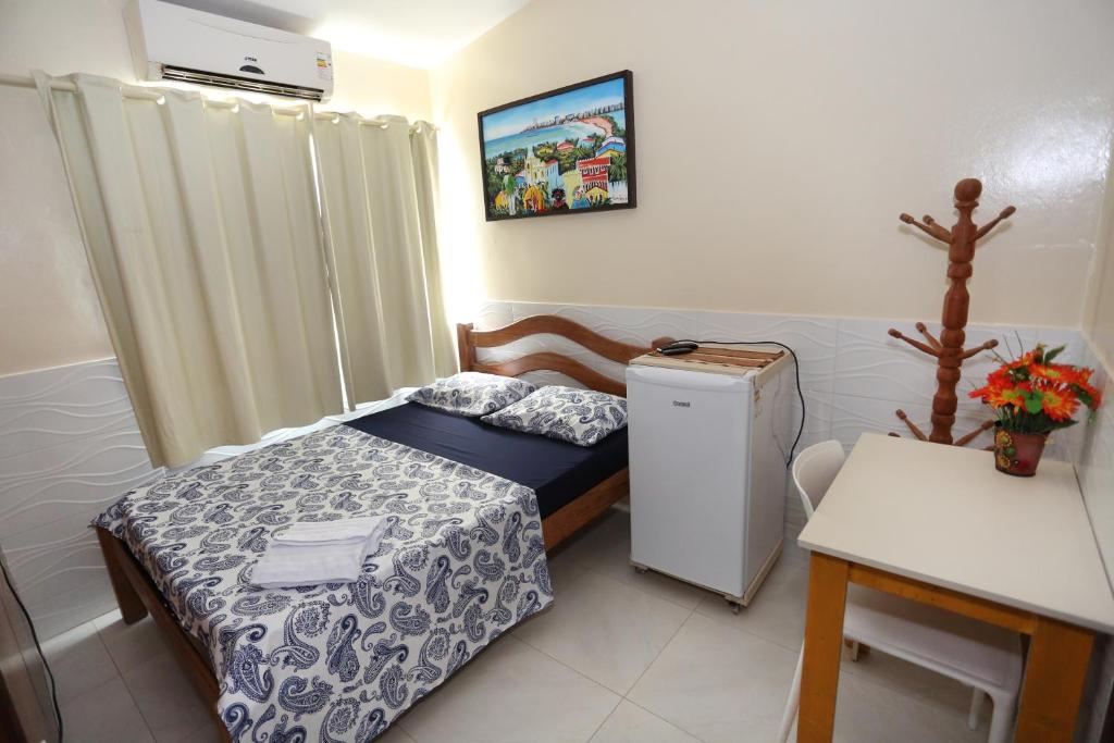 a small room with a bed and a refrigerator at Paraíso Olindense in Olinda