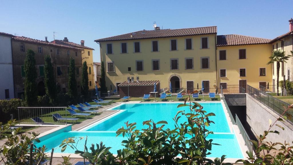 einen Pool mit Stühlen und ein Gebäude in der Unterkunft Borgo di Gramugnana in Usigliano