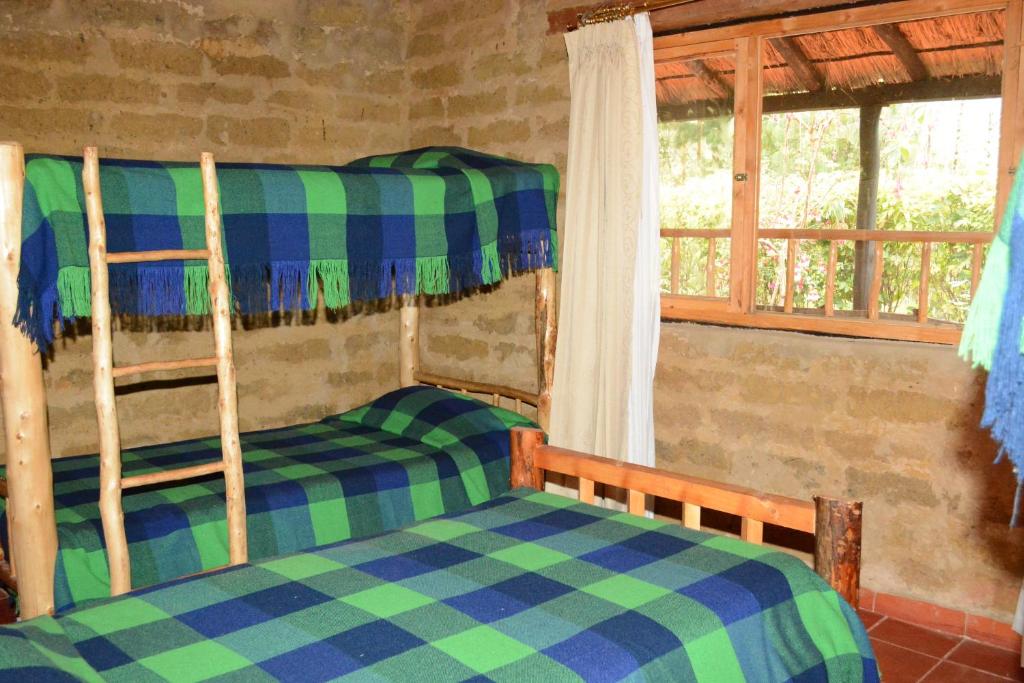 a bedroom with two bunk beds and a window at Monzaque- paraíso de bachué in El Barrial