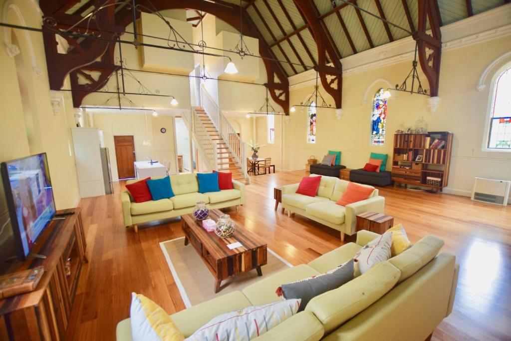 a large living room with couches and a tv at The Church @ Woodford in Woodford