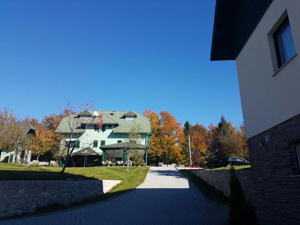 uma casa grande com um telhado verde numa rua em Villa Lika 1 em Plitvicka Jezera