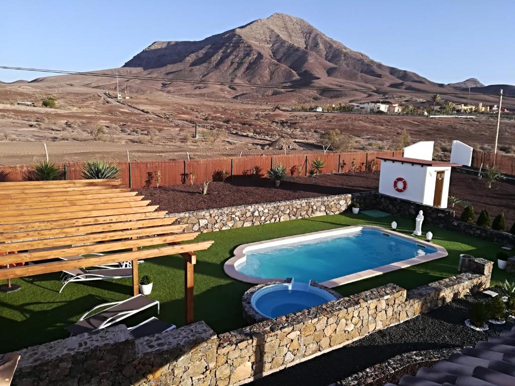 a backyard with a pool and a table and a mountain at Casa palmito in Tesejerague