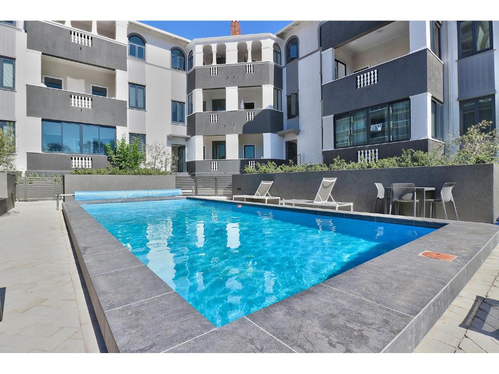 a swimming pool in front of a building at Greenpoint Apartments in Cape Town
