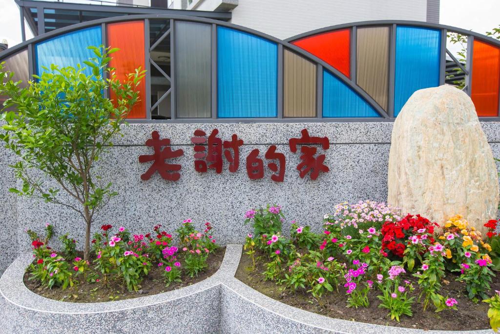 um cartaz com flores em frente a um edifício em Hsieh's Home em Taitung City