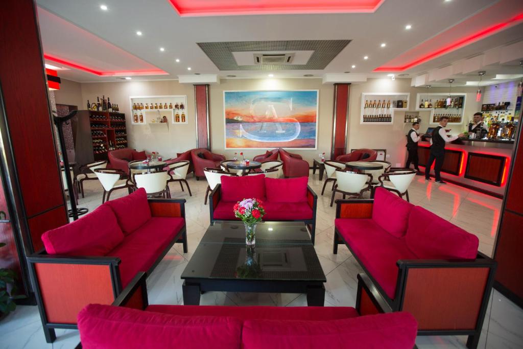restauracja z czerwonymi krzesłami i stołami oraz bar w obiekcie Hotel Palma w mieście Rinas