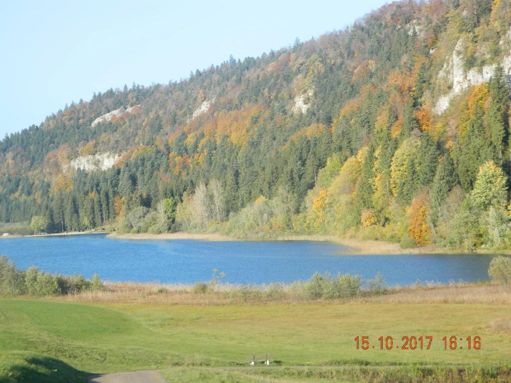 un grand lac bleu en face d'une montagne dans l'établissement la berlie du jura, à Étival