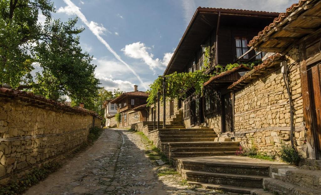 an alley in an old village with stone buildings at Kodjamanova House in Zheravna