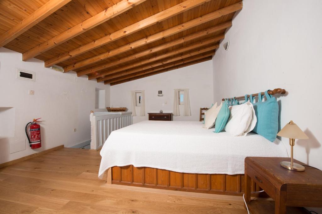 a bedroom with a large bed with blue pillows at Villa Petros in Symi