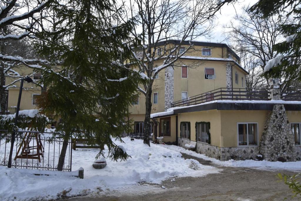 a house with snow on the ground in front of it at Albergo Del Sole in Roccaraso