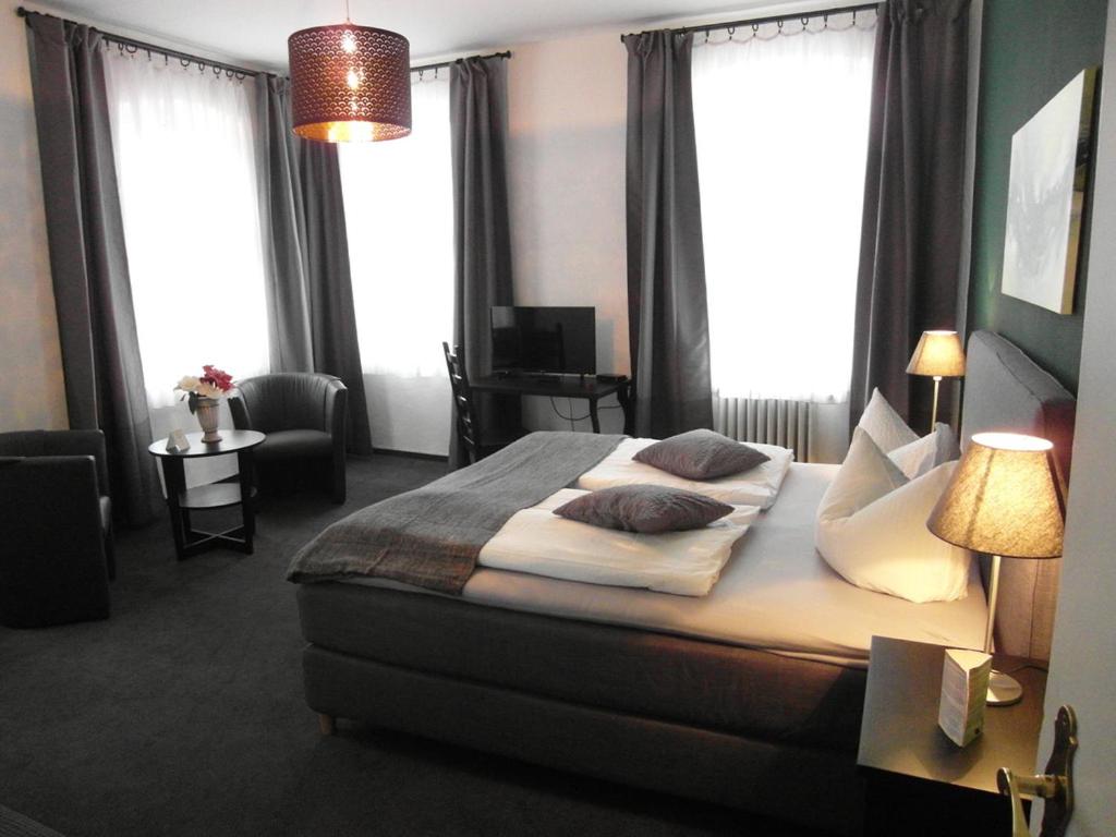 a bedroom with a large bed with pillows on it at Hotel Frankfurter Hof in Limburg an der Lahn