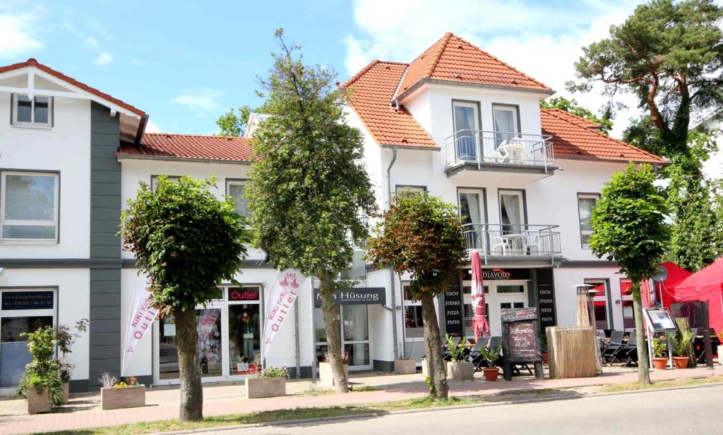 a group of buildings on a street with trees at Min Hüsung by Rujana in Binz