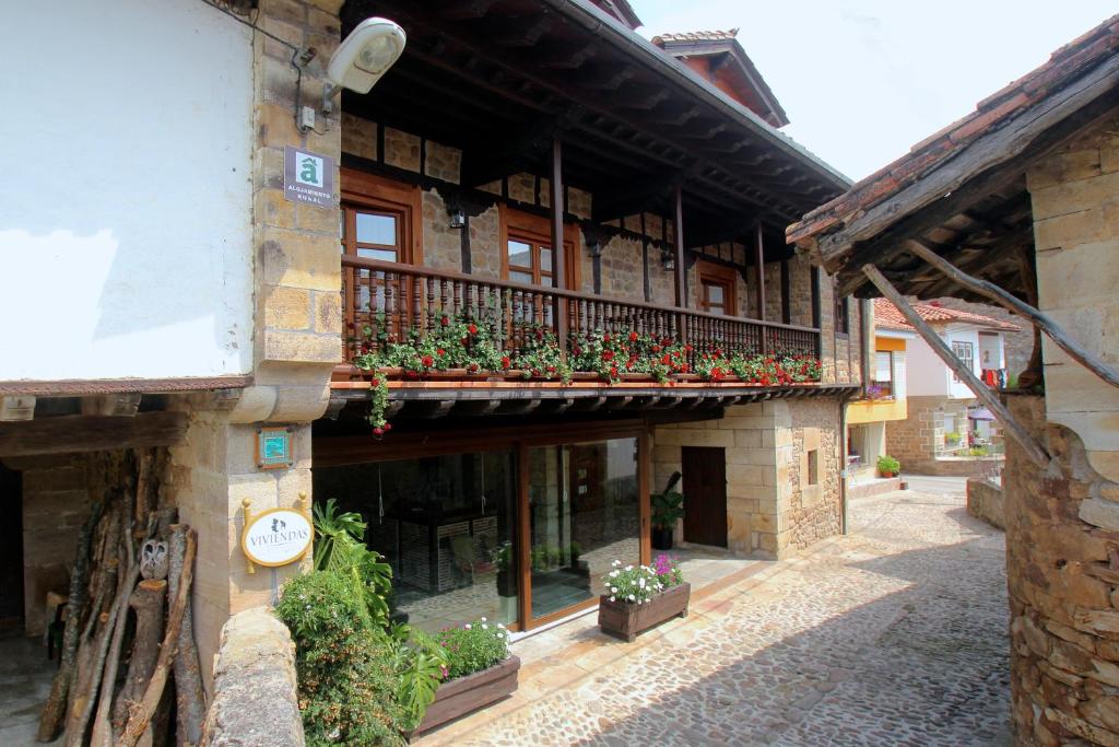 a building with a balcony with potted plants on it at Apartamentos Rurales Pedredo in Pedredo