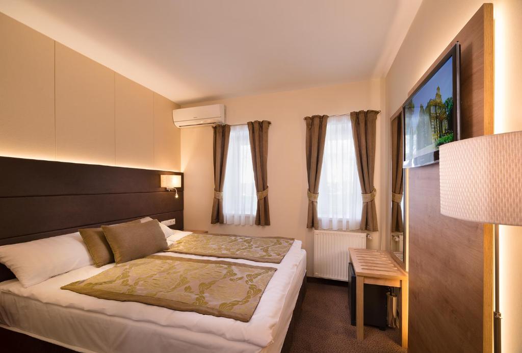 Rúm í herbergi á Hotel Honti Wellness és Konferencia Szálloda