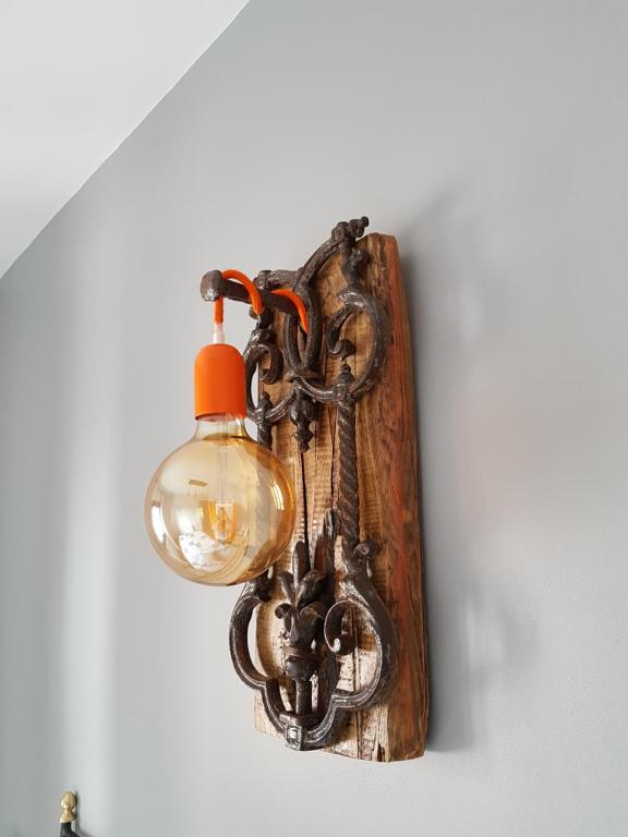 una luz colgada en una pared con una cadena y una lámpara en Apartamentos Serendipia, en Santillana del Mar