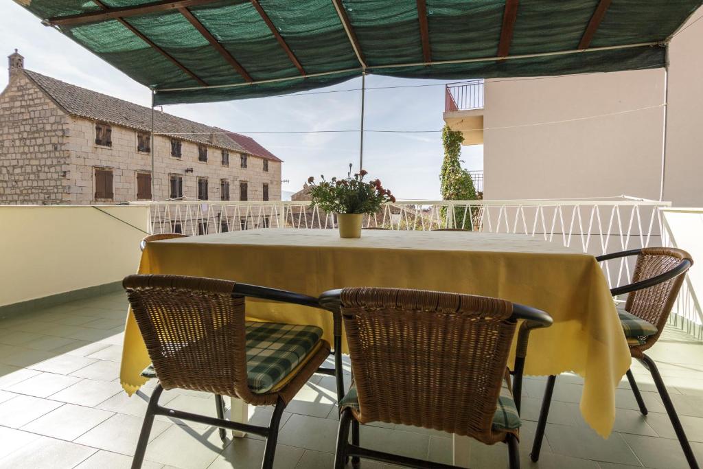 una mesa amarilla y sillas en el balcón en Apartman Željka, en Komiža