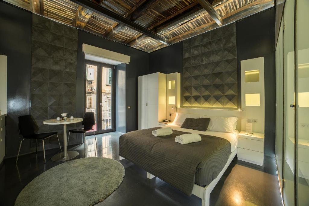 ナポリにあるChiaia 197 Deluxe Residenceのベッドルーム1室(ベッド1台、テーブル、窓付)