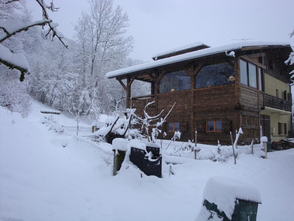 a log cabin in the snow with snow covered trees at Chambres d'Hôtes Chalet de la Source in Morillon
