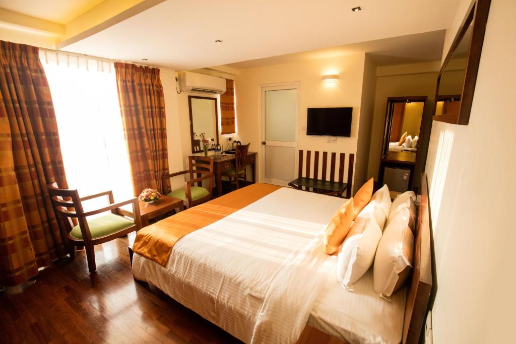 a hotel room with a bed and a television at GSH Colombo in Colombo