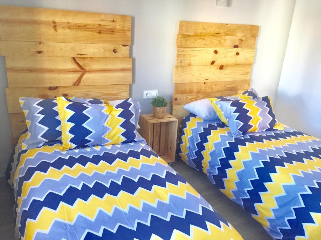 two beds sitting next to each other in a bedroom at Apartamentos Rurales el Trillo in Malpartida de Plasencia