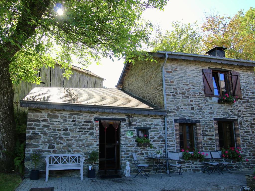 a stone house with a bench in front of it at Attractive Cottage in Baillamont with Terrace in Bièvre