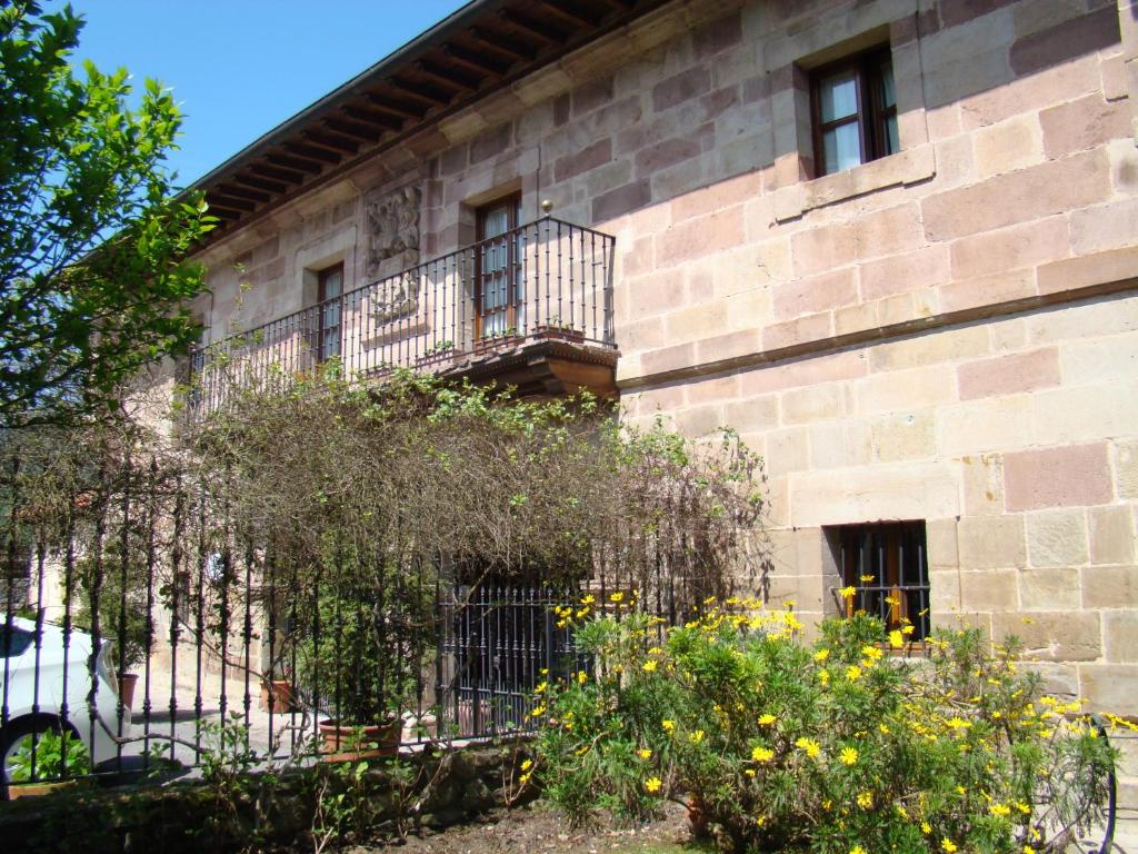 a building with a balcony on the side of it at Casona De La Salceda in Treceño