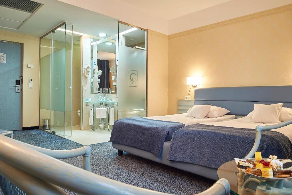 a hotel room with a bed and a bathroom at Continental Forum Sibiu in Sibiu