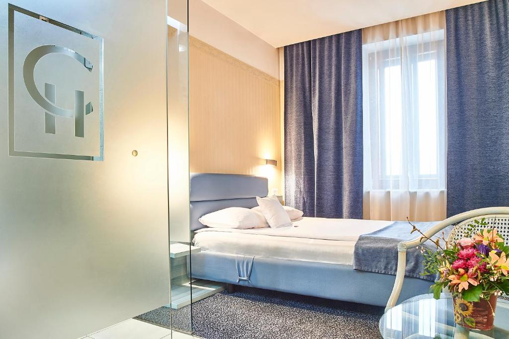 a hotel room with a bed and a mirror at Continental Forum Sibiu in Sibiu