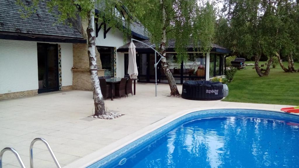 a swimming pool in front of a house at Willa SASINO in Sasino
